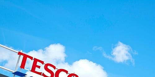 Tesco extra supermarket sign against a blue sky